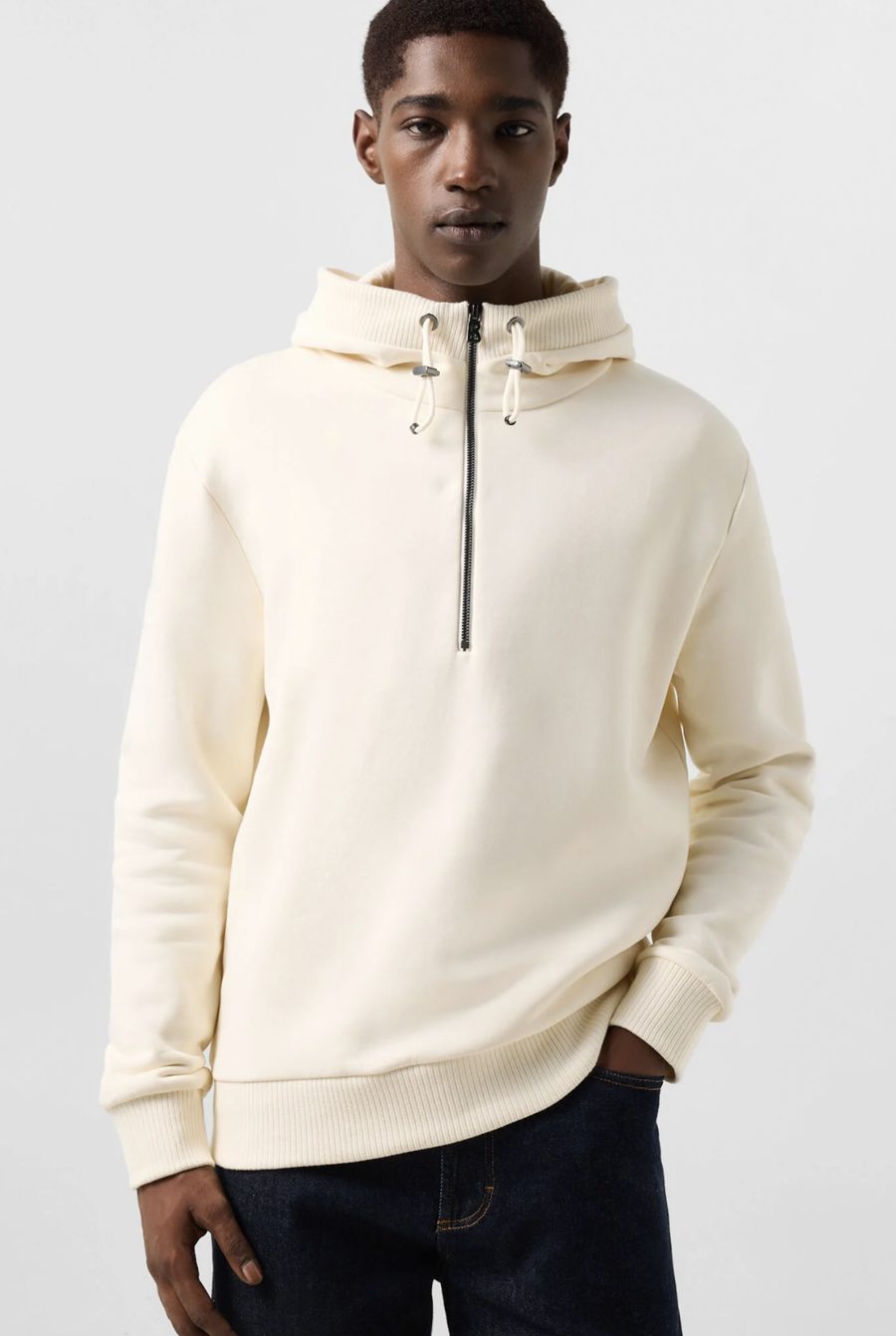 Sweat à capuche demi-zip blanc cassé, porté avec un jean brut