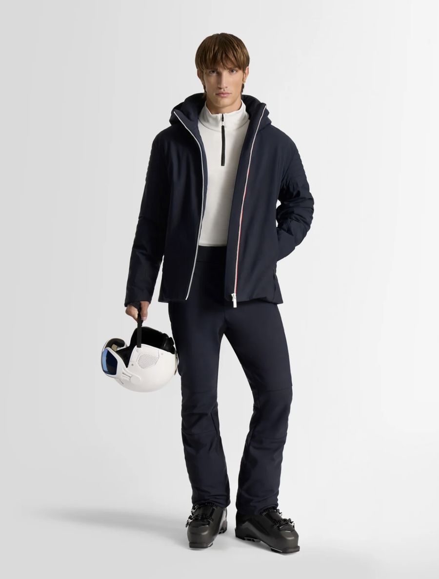 Veste de ski bleu marine à zip tricolore, sous-pull blanc et pantalon assorti